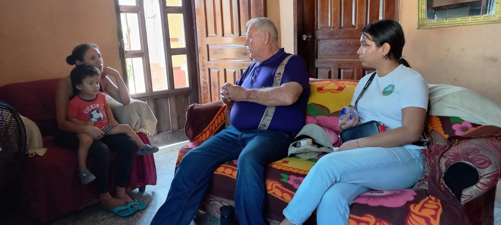 A group of people are sitting on a couch in a living room.