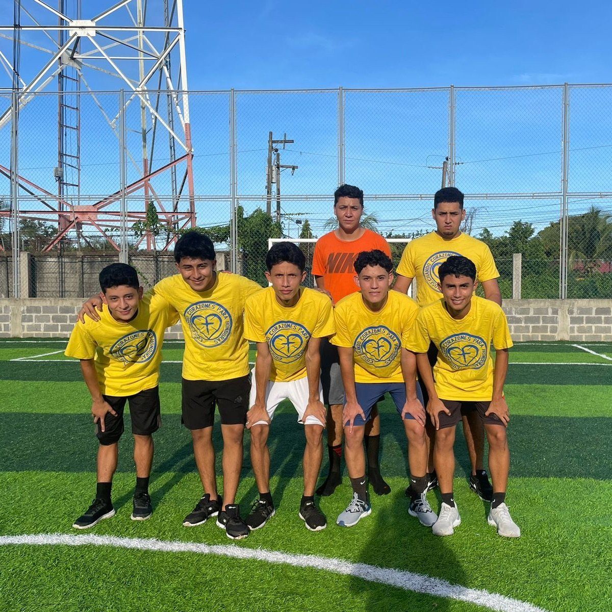 A group of young men are posing for a picture on a soccer field.