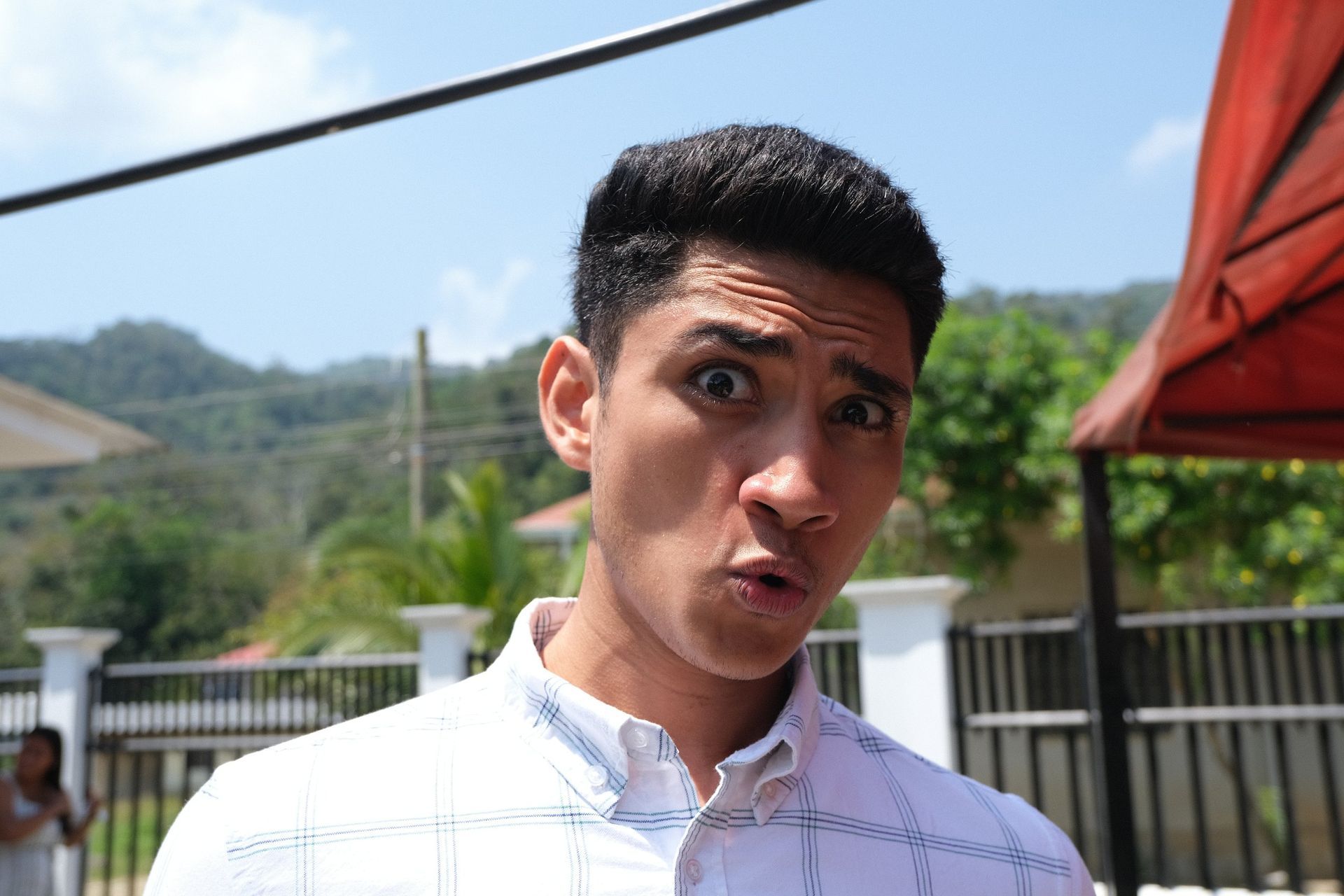 A man in a white shirt is making a funny face.