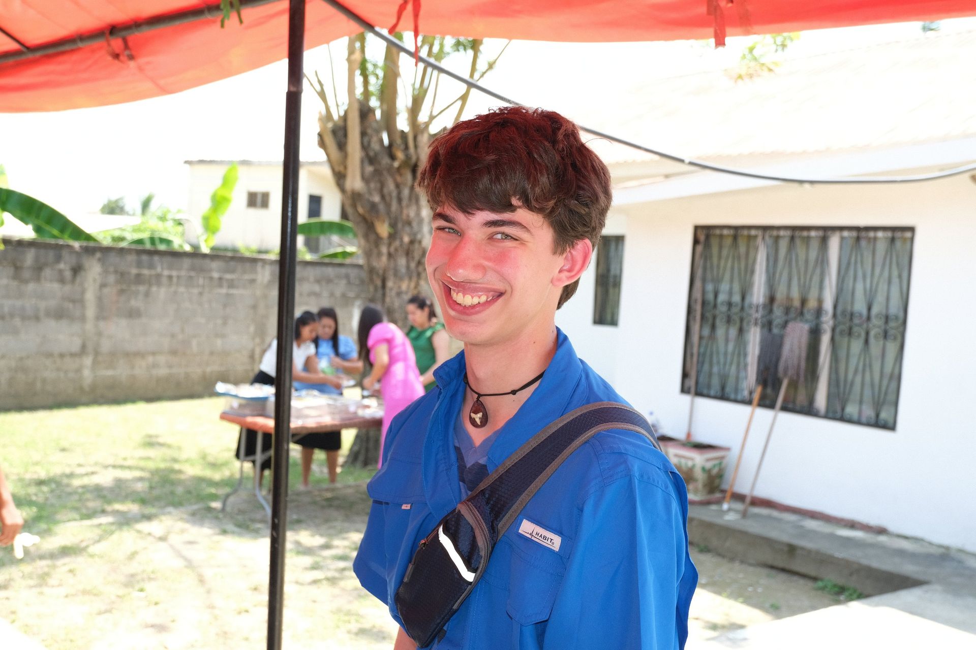 A young man wearing a blue shirt with the word epson on it