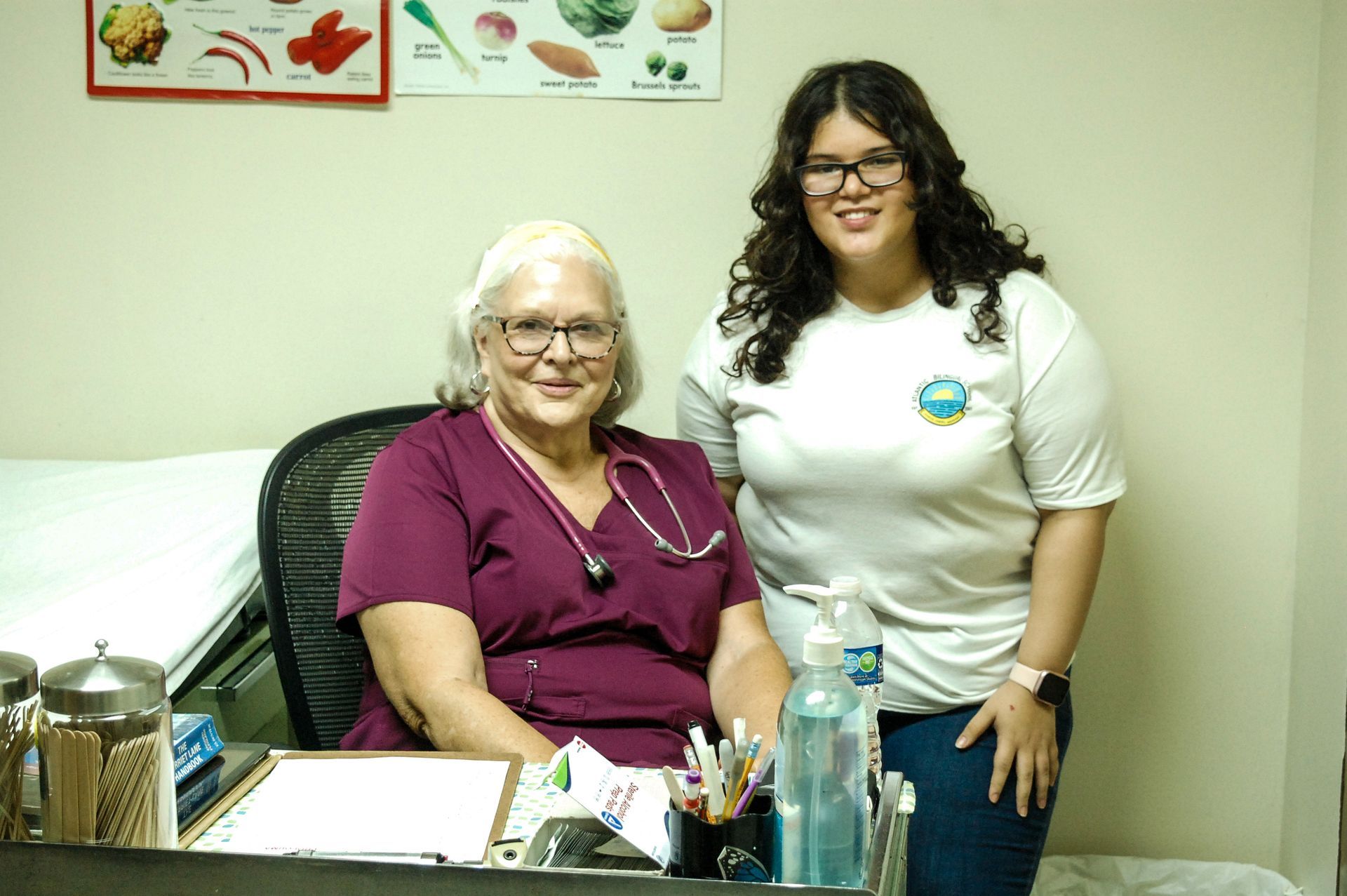 Two women are standing next to each other in a doctor 's office.
