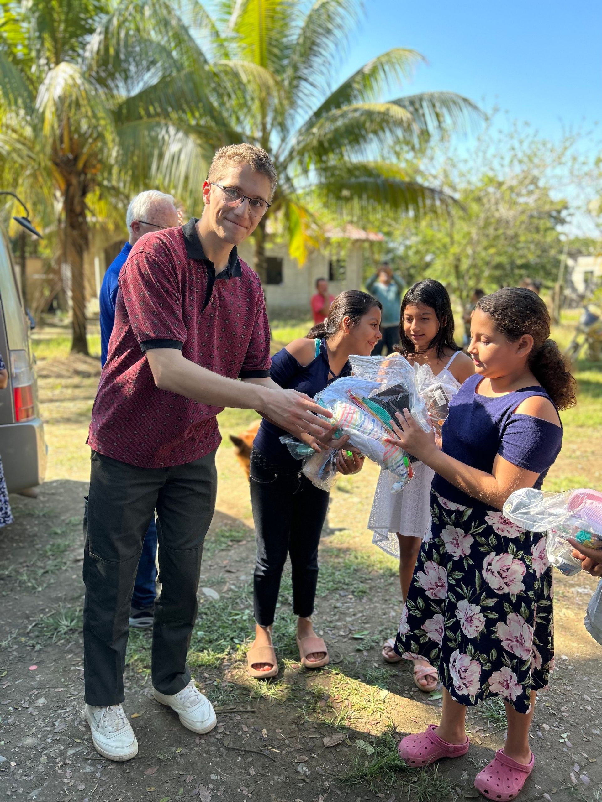 A man is giving a gift to a group of children.