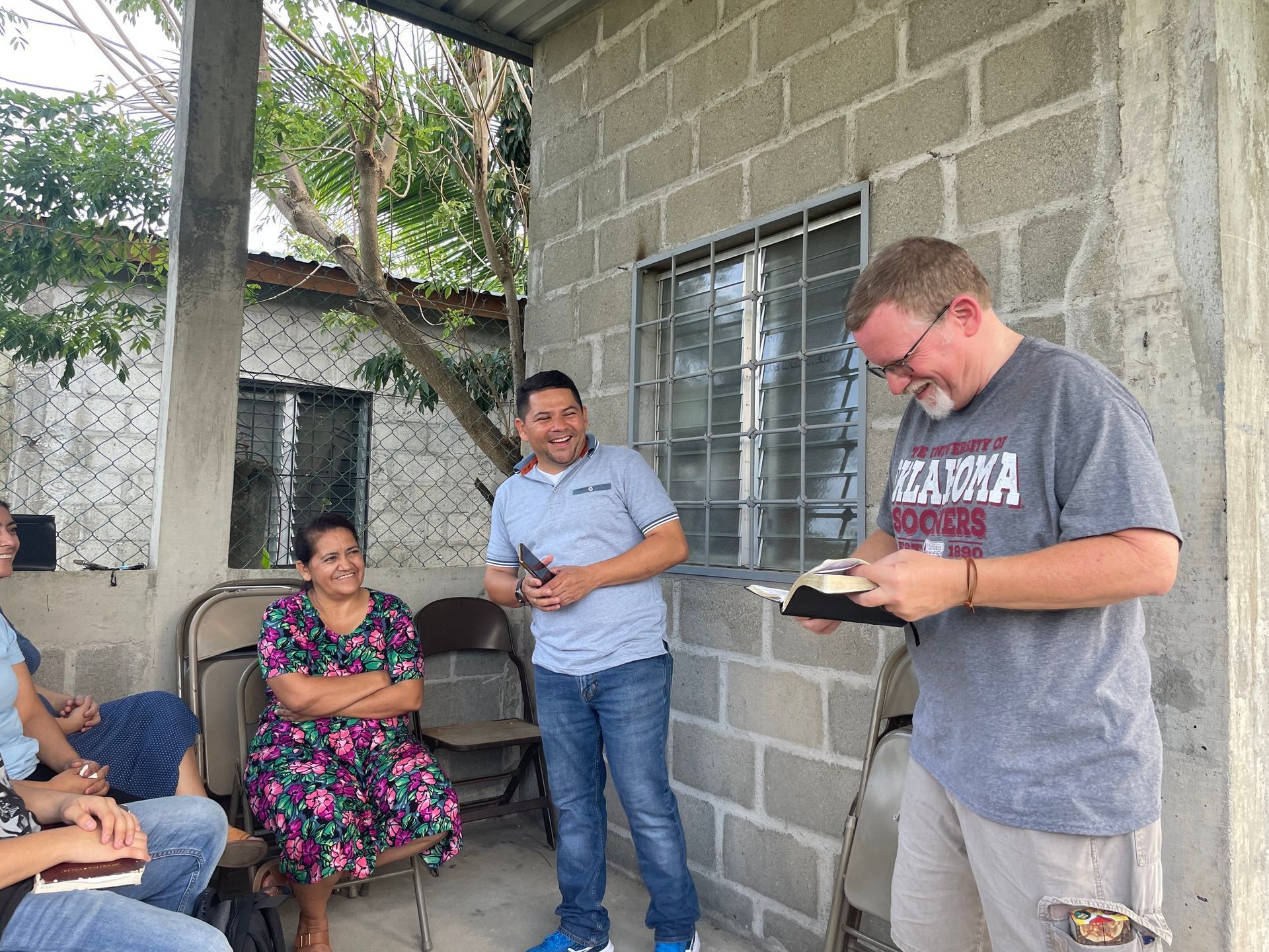 A man is holding a bible in front of a group of people.