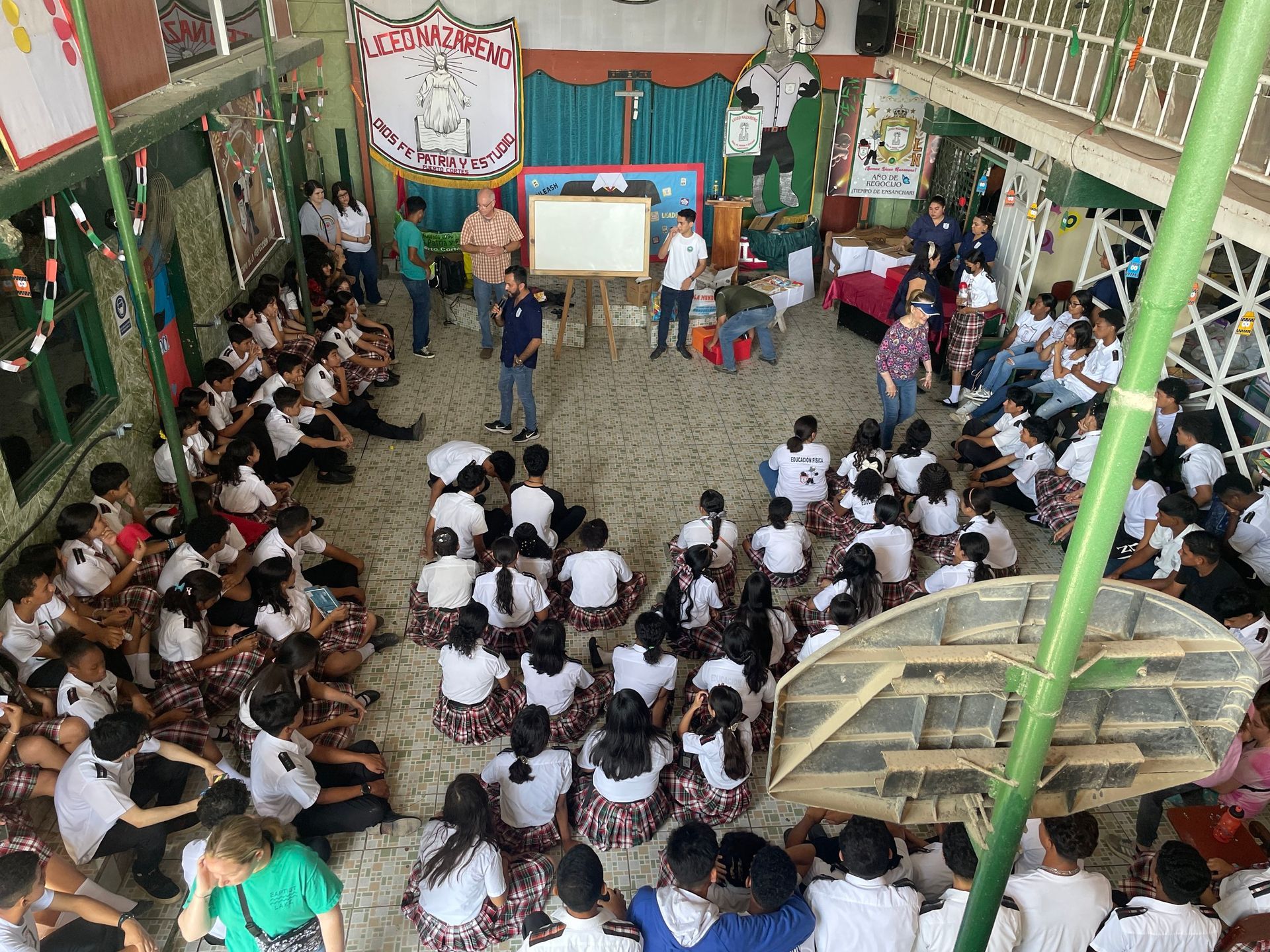 A large group of people are sitting on the floor in a room.