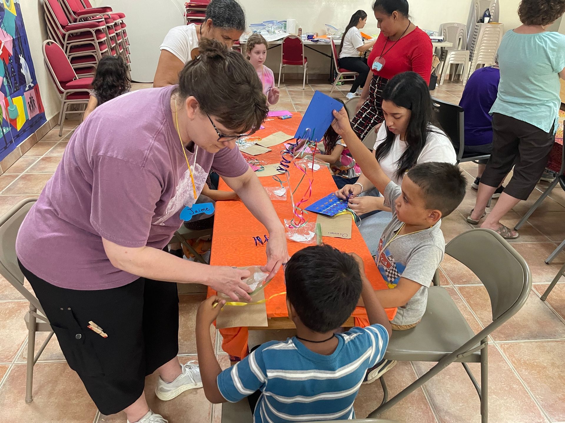 A group of people are sitting around a table making crafts.