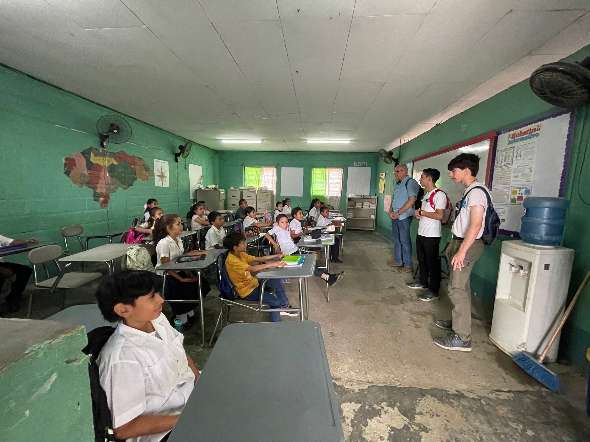 A group of children are sitting at desks in a classroom.