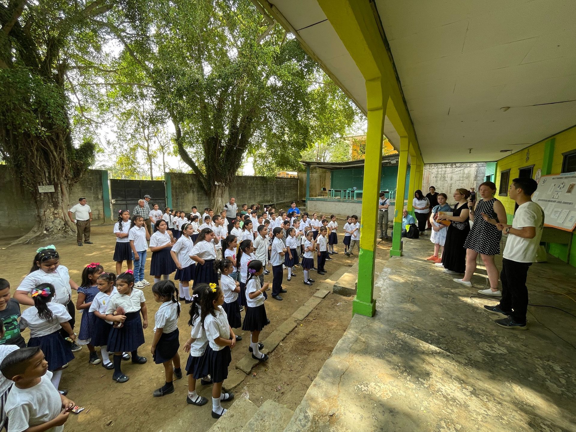 A group of children are standing outside of a school building.