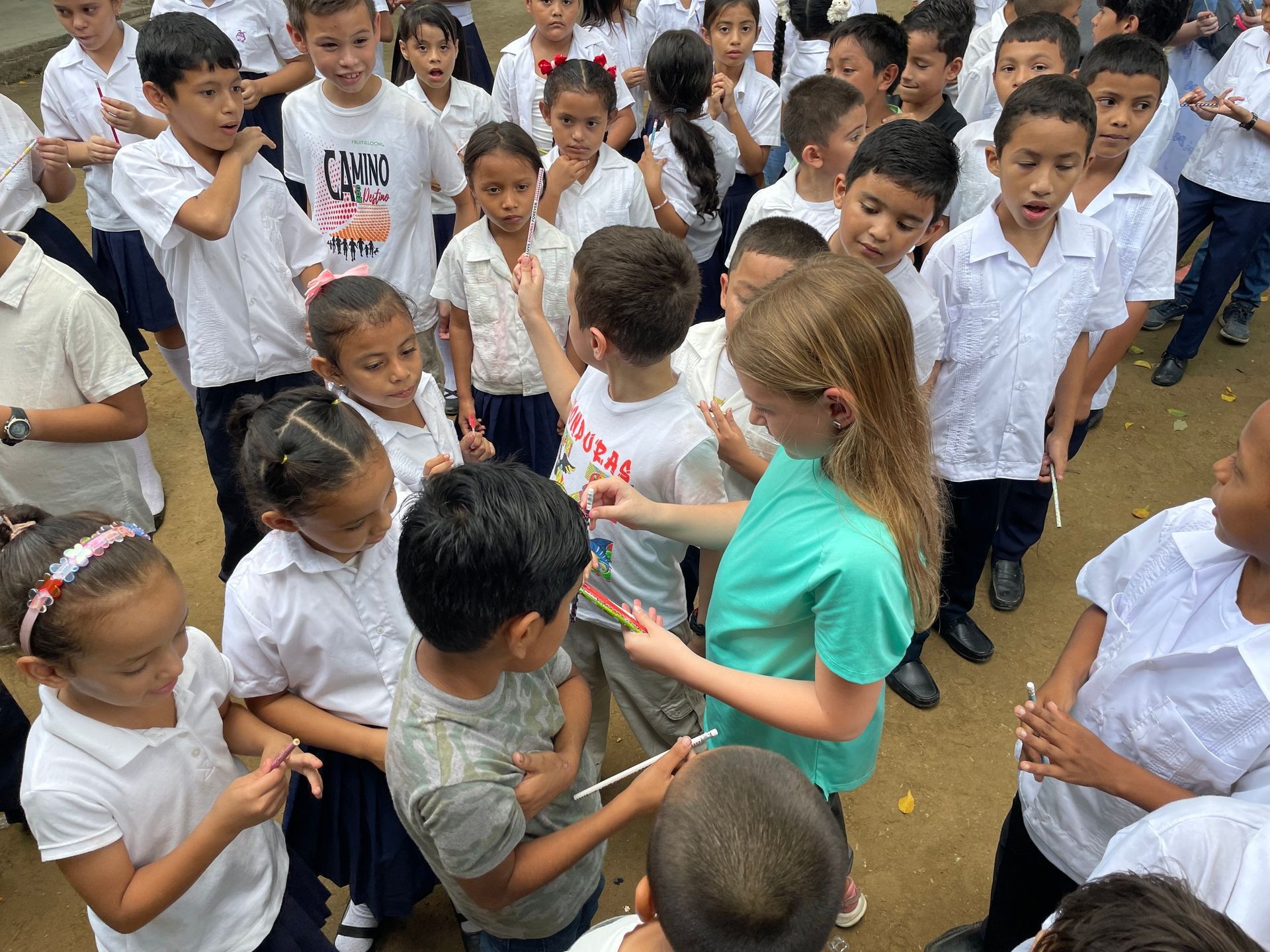 A girl in a green shirt is talking to a group of children