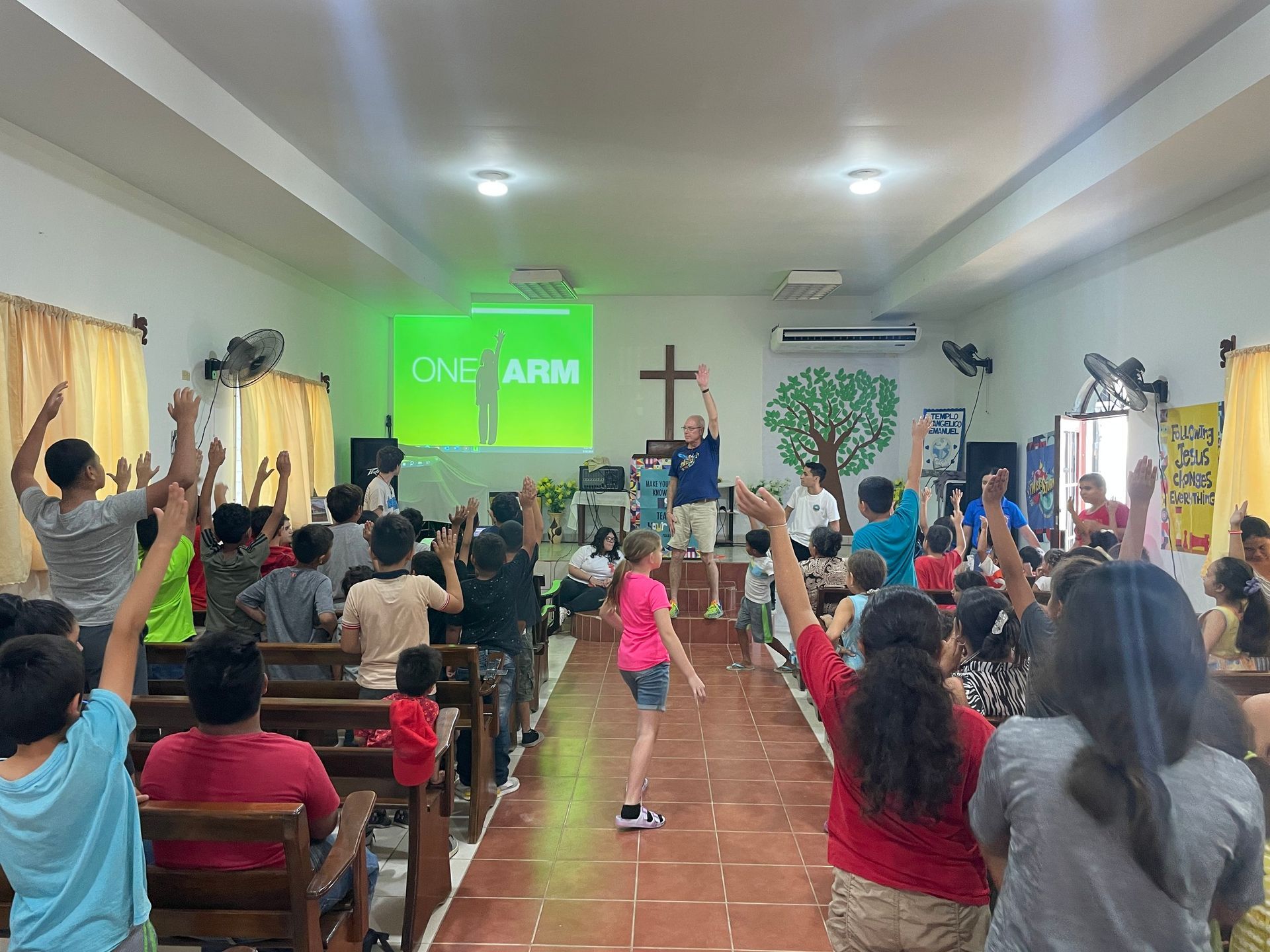 A group of people are raising their hands in a church.