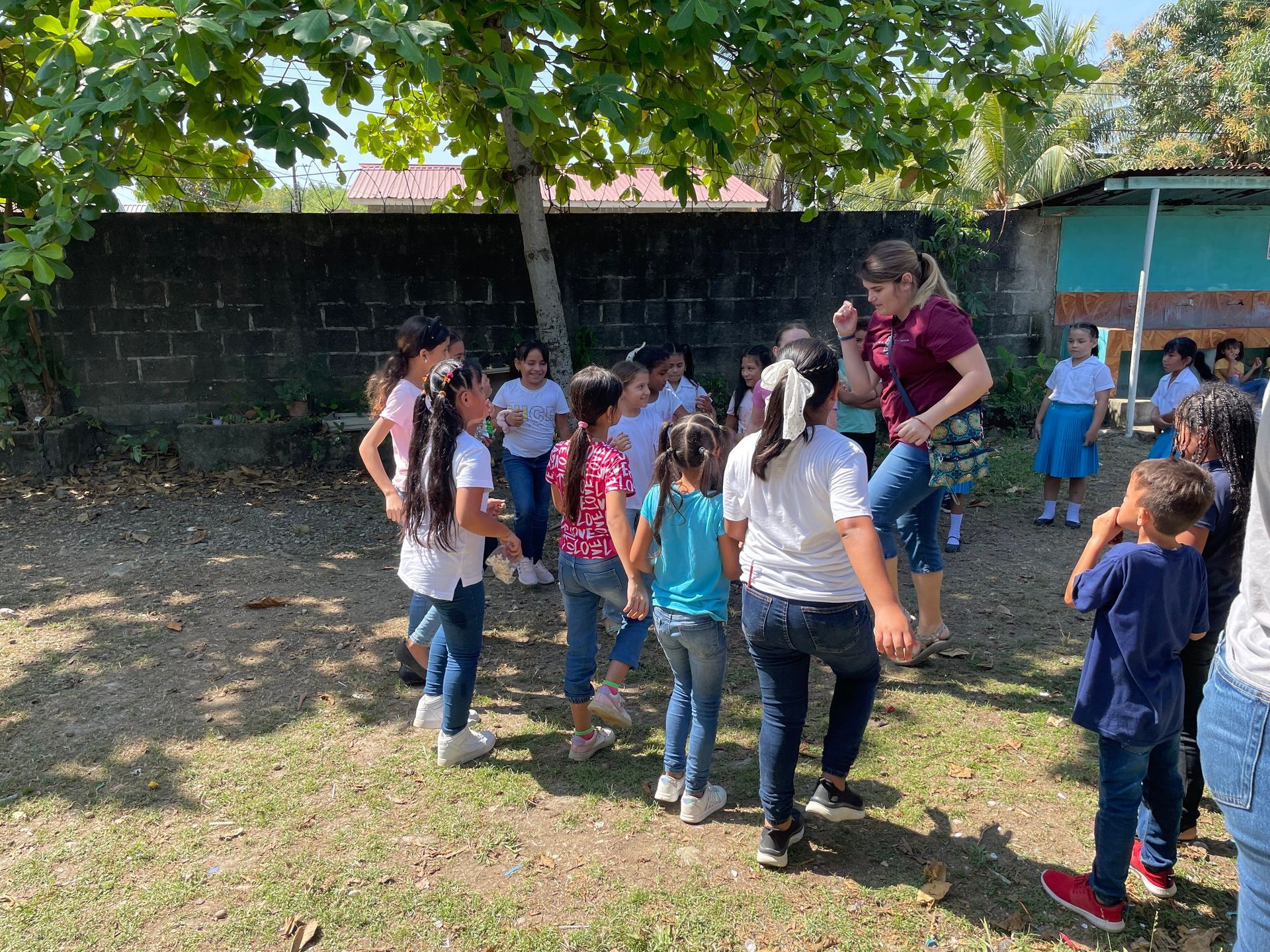 A group of children are standing in a circle in a field.