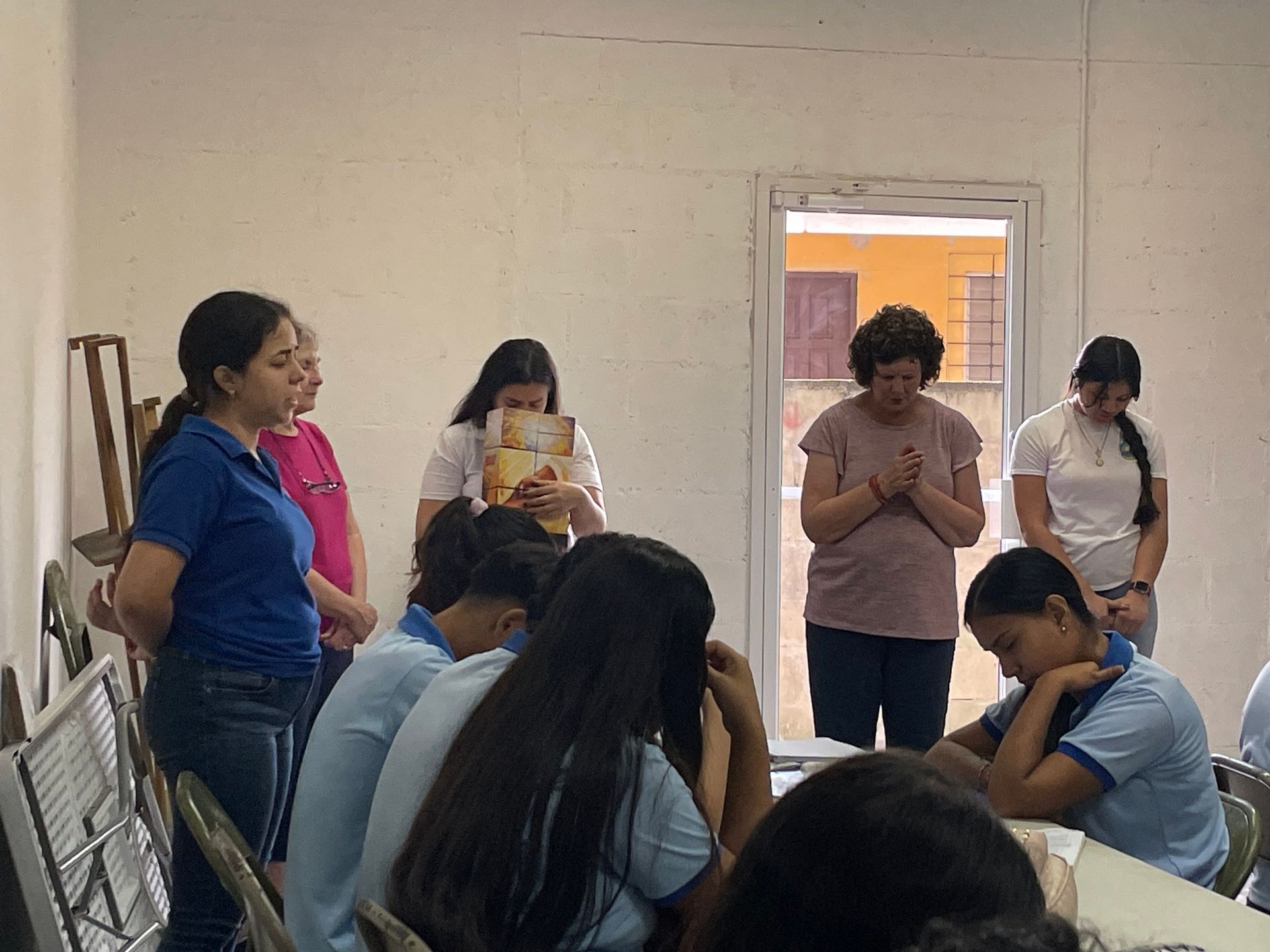 A group of young women are sitting at a table in a room.