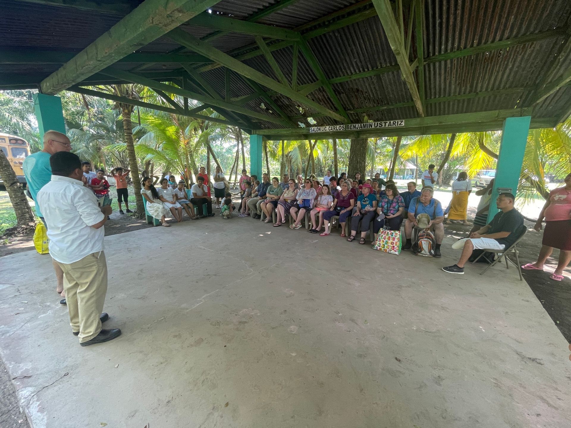 A group of people are sitting under a covered area.