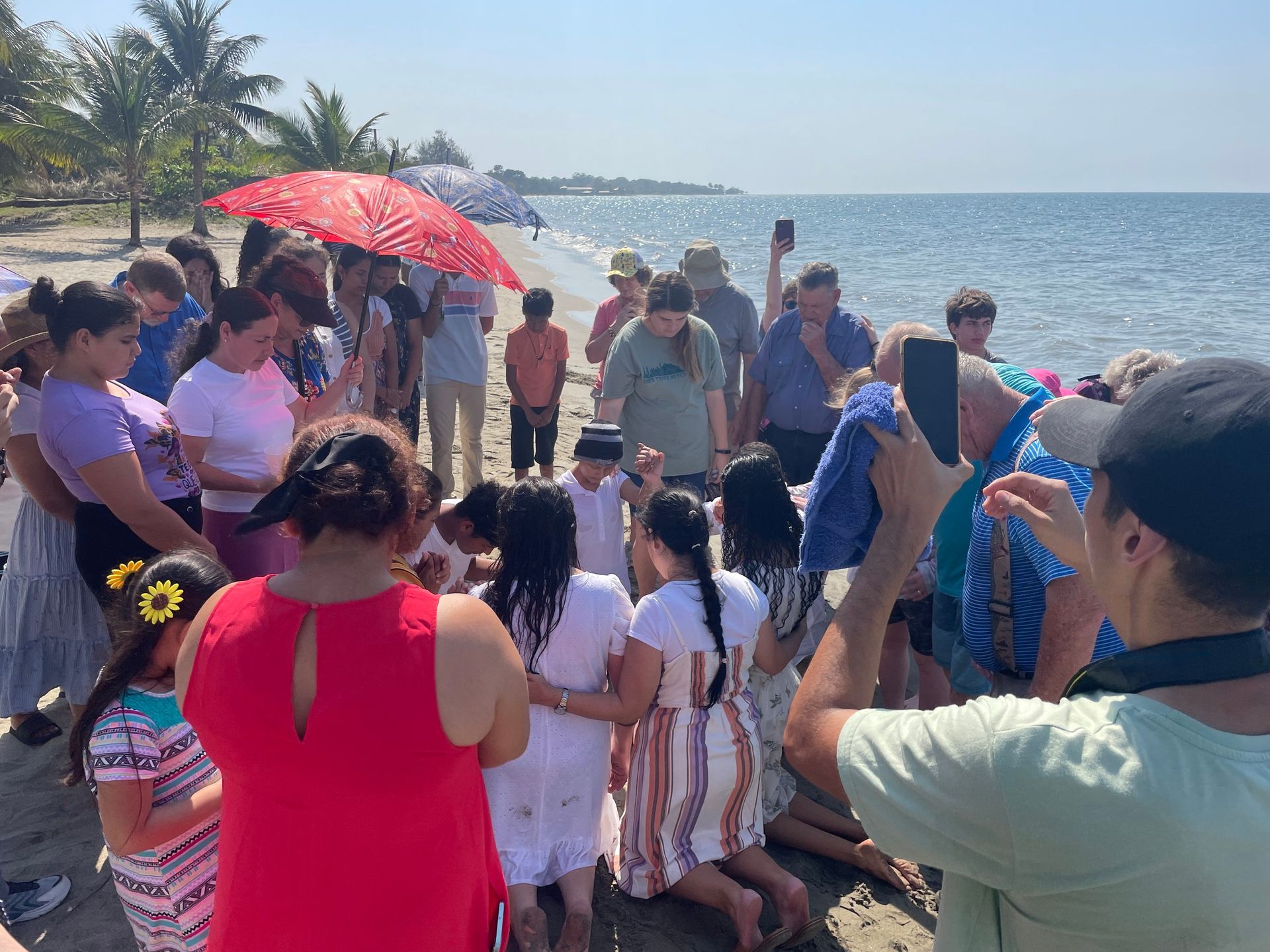 A man is taking a picture of a group of people on the beach.