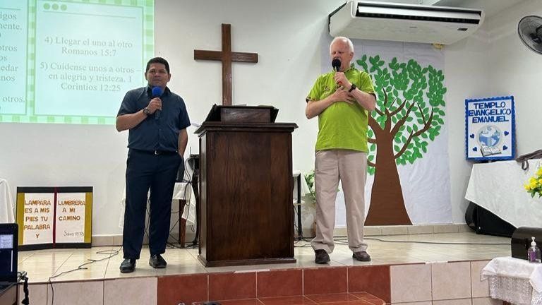 Two men are standing in front of a podium in a church.