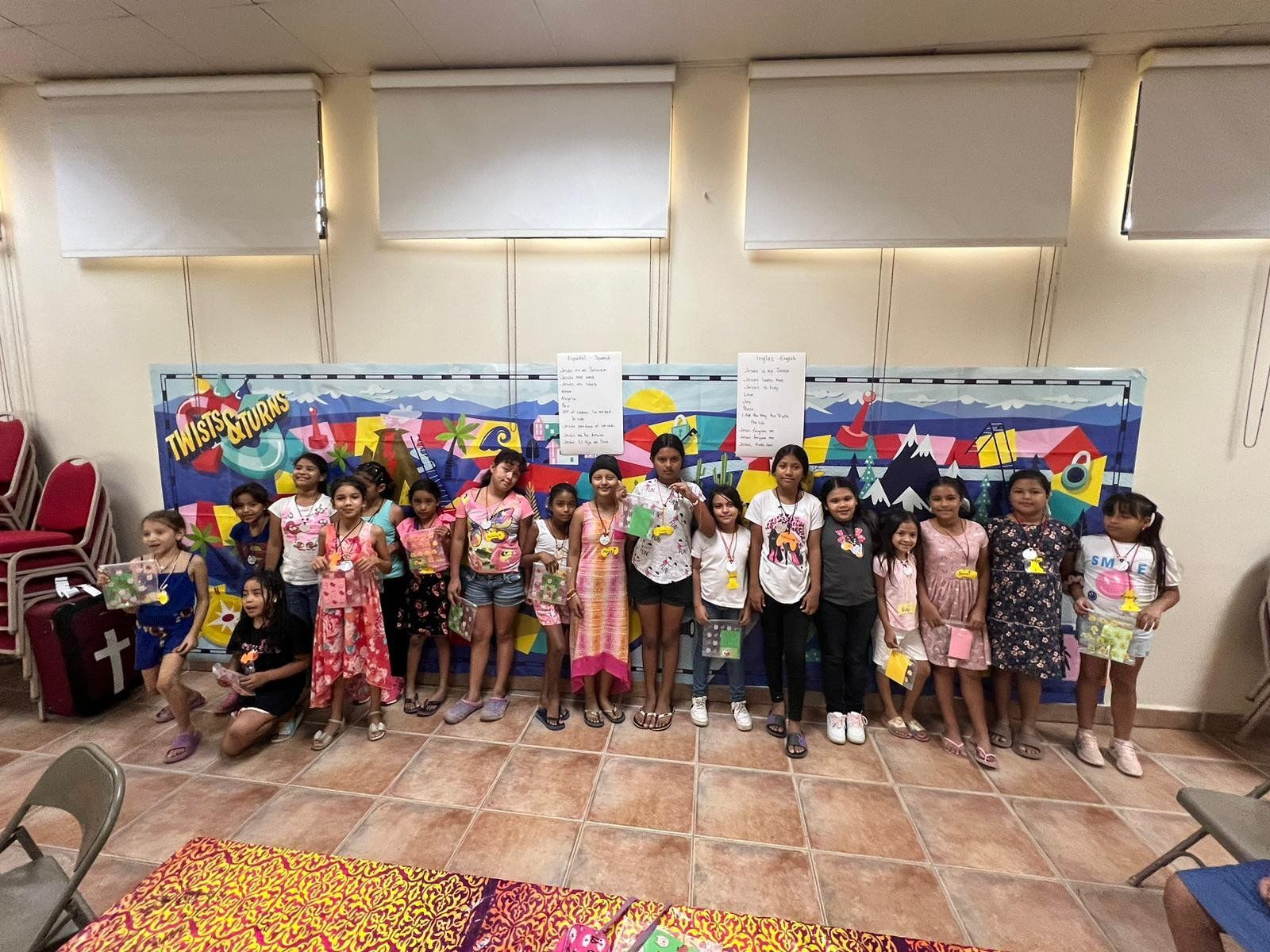 A group of children are posing for a picture in a room.