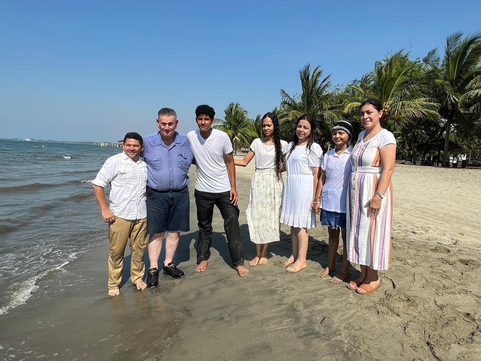 A group of people are posing for a picture on the beach.