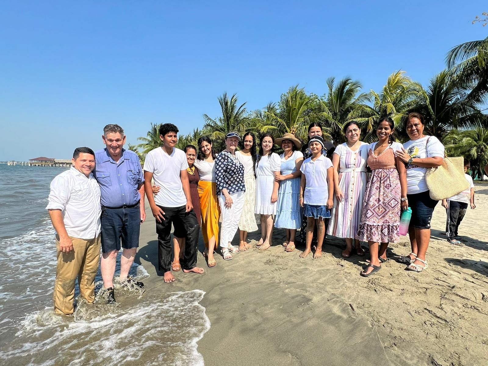 A group of people are posing for a picture on the beach.