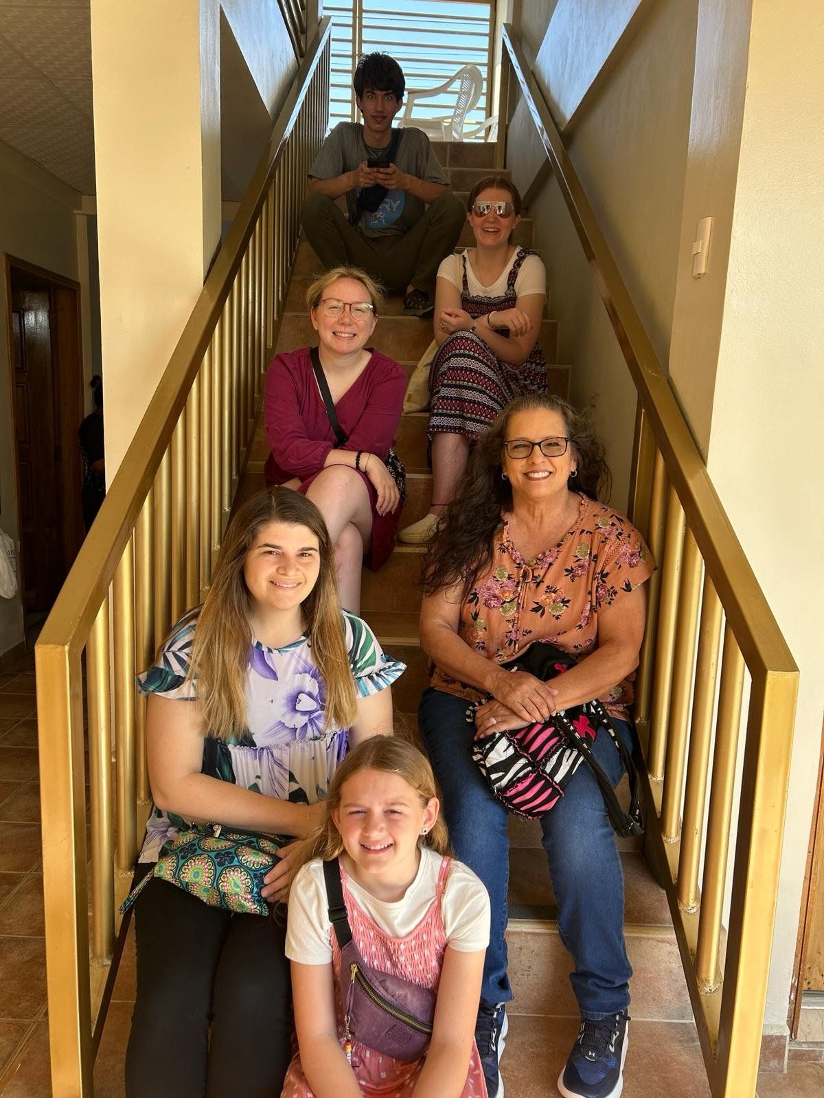 A group of people are sitting on a set of stairs.