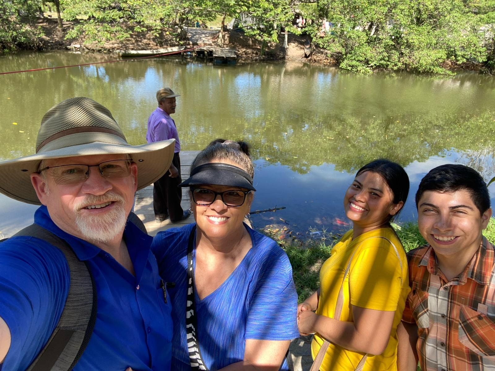 A group of people are posing for a picture in front of a lake.