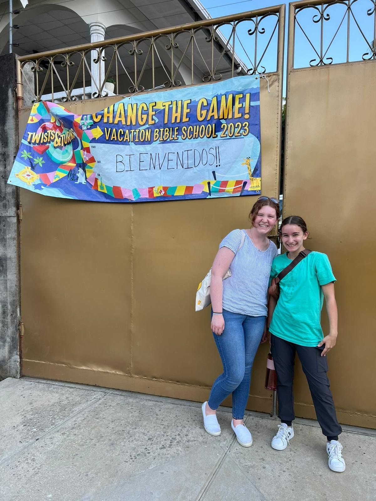 Two women are standing in front of a sign that says change the game.