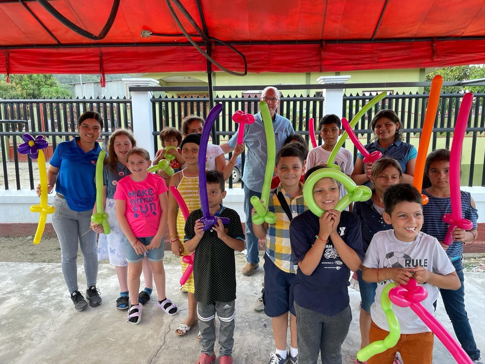 A group of children are posing for a picture with balloons in their hands.