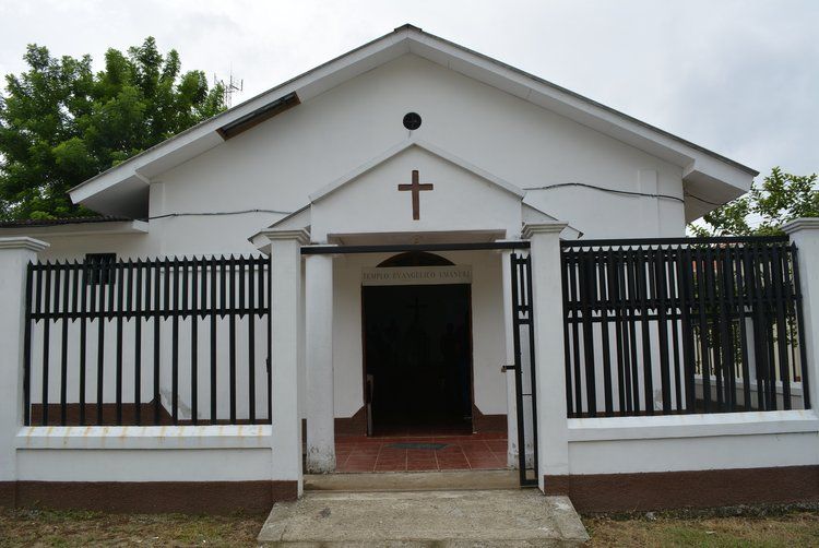 A white building with a cross on top of it