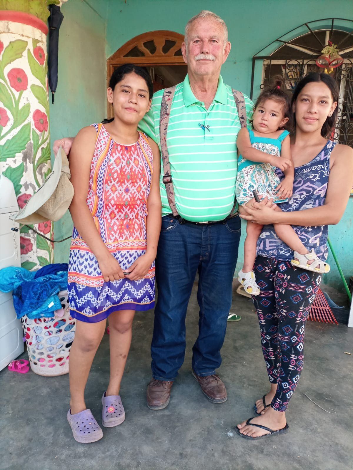 A man and two women are posing for a picture with a child in their arms.
