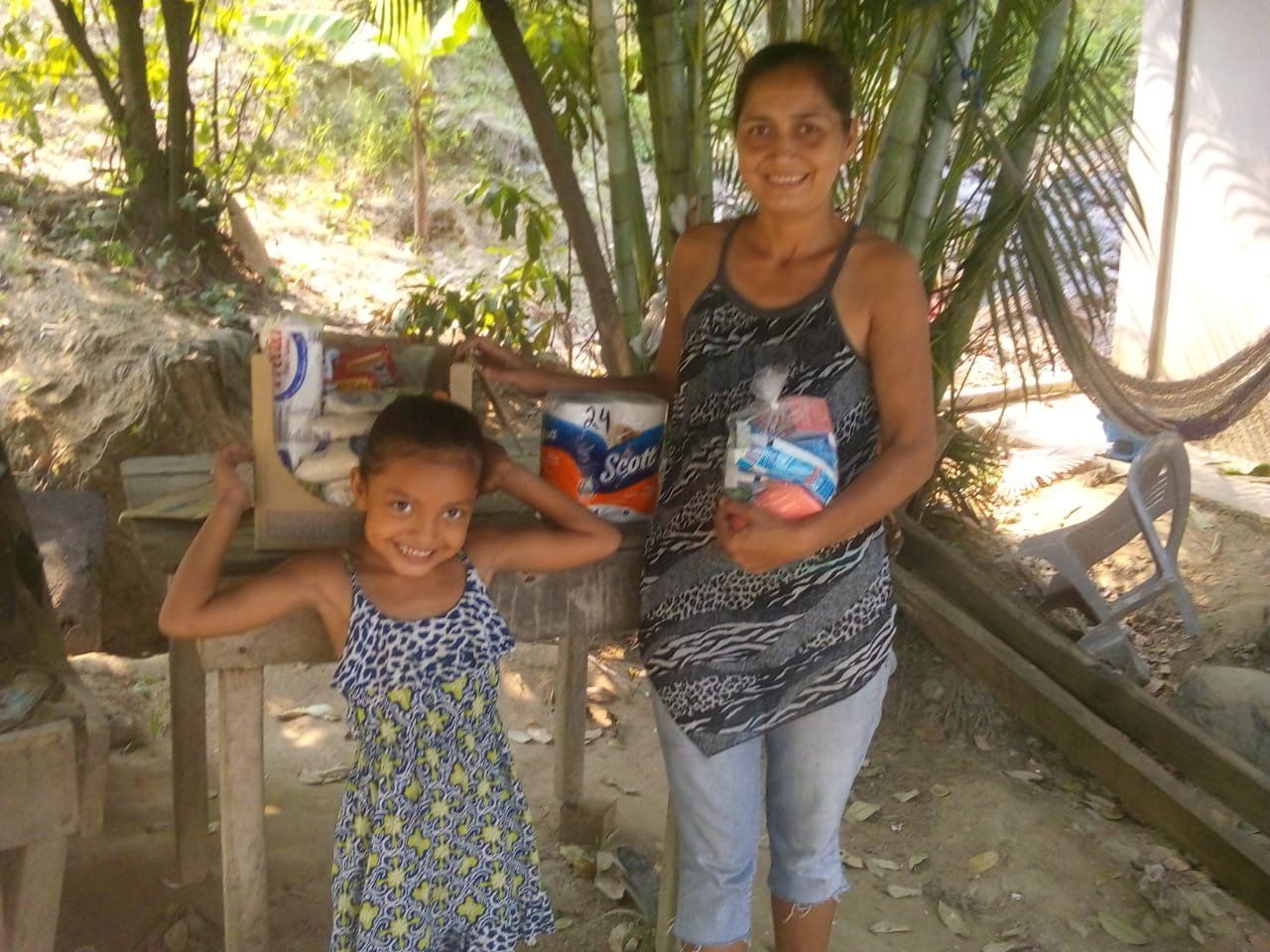 A woman and a little girl are standing next to each other holding toilet paper rolls.