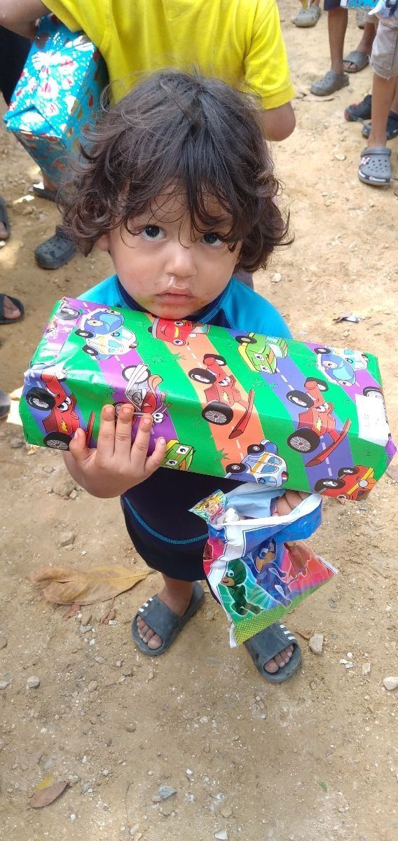 A little boy is holding a gift box in his hand.