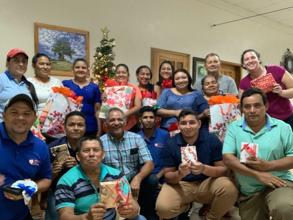 A group of people are posing for a picture in front of a christmas tree.