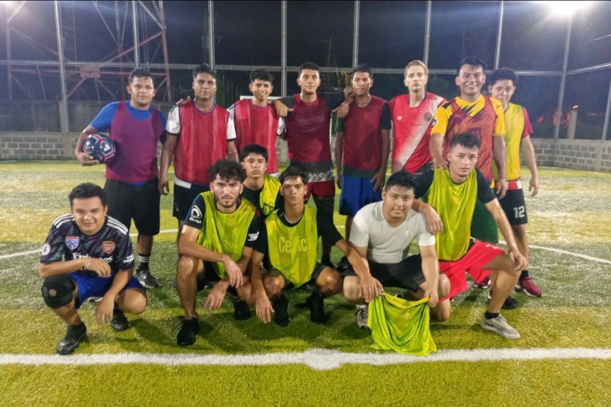 A group of young men are posing for a picture on a soccer field.