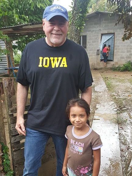 A man wearing an iowa shirt stands next to a little girl
