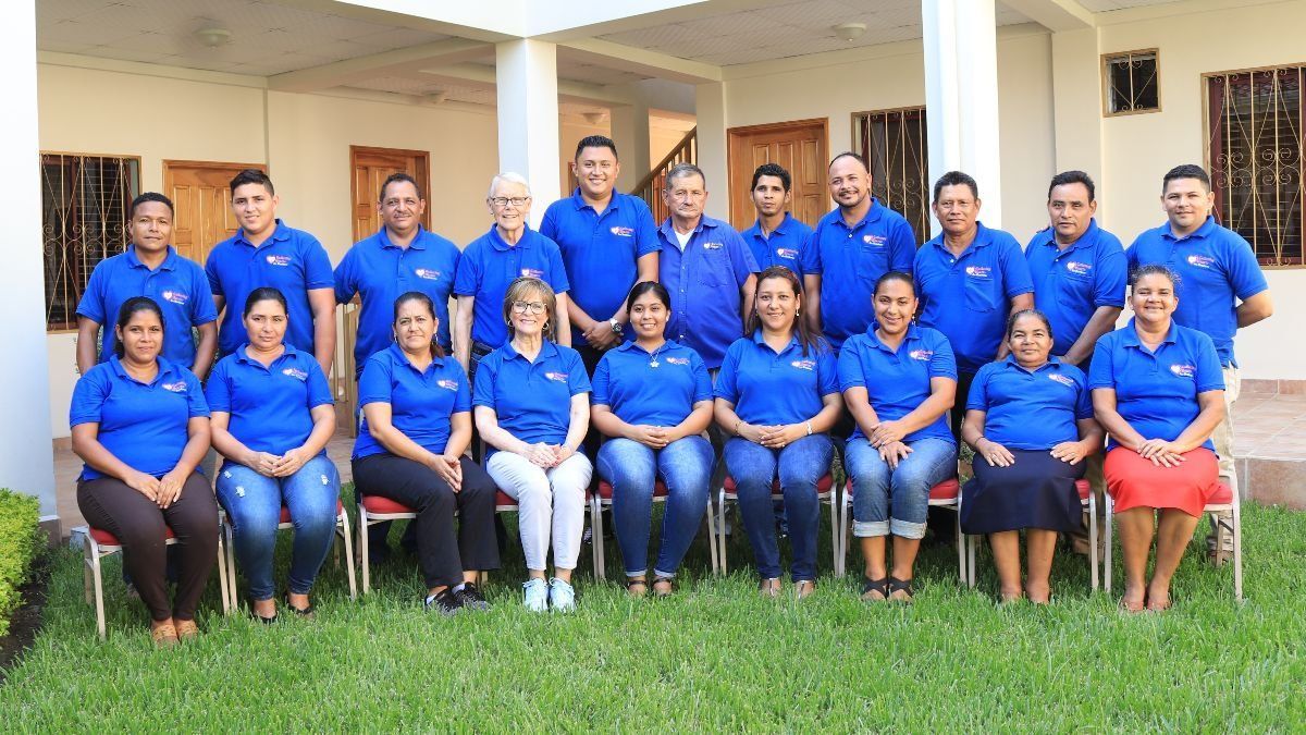 A group of people in blue shirts are posing for a picture.