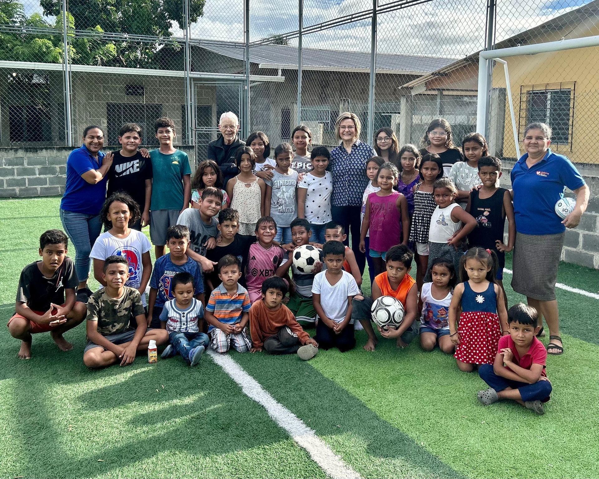A group of children are posing for a picture on a soccer field.