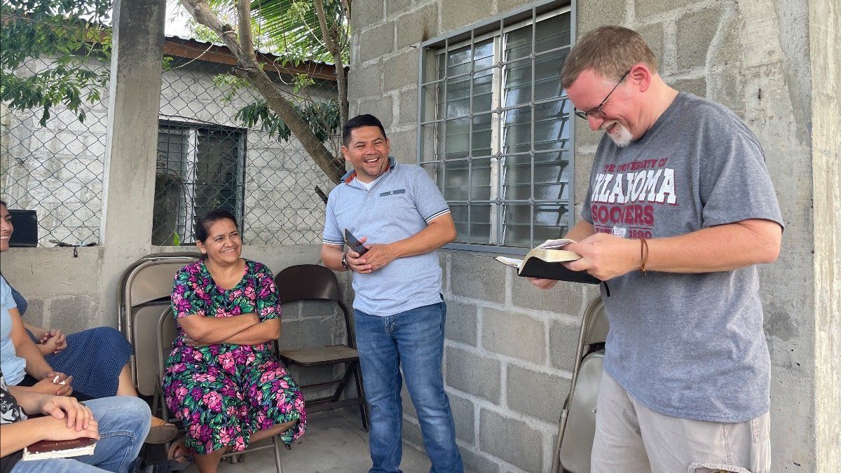 A man is holding a bible in front of a group of people.