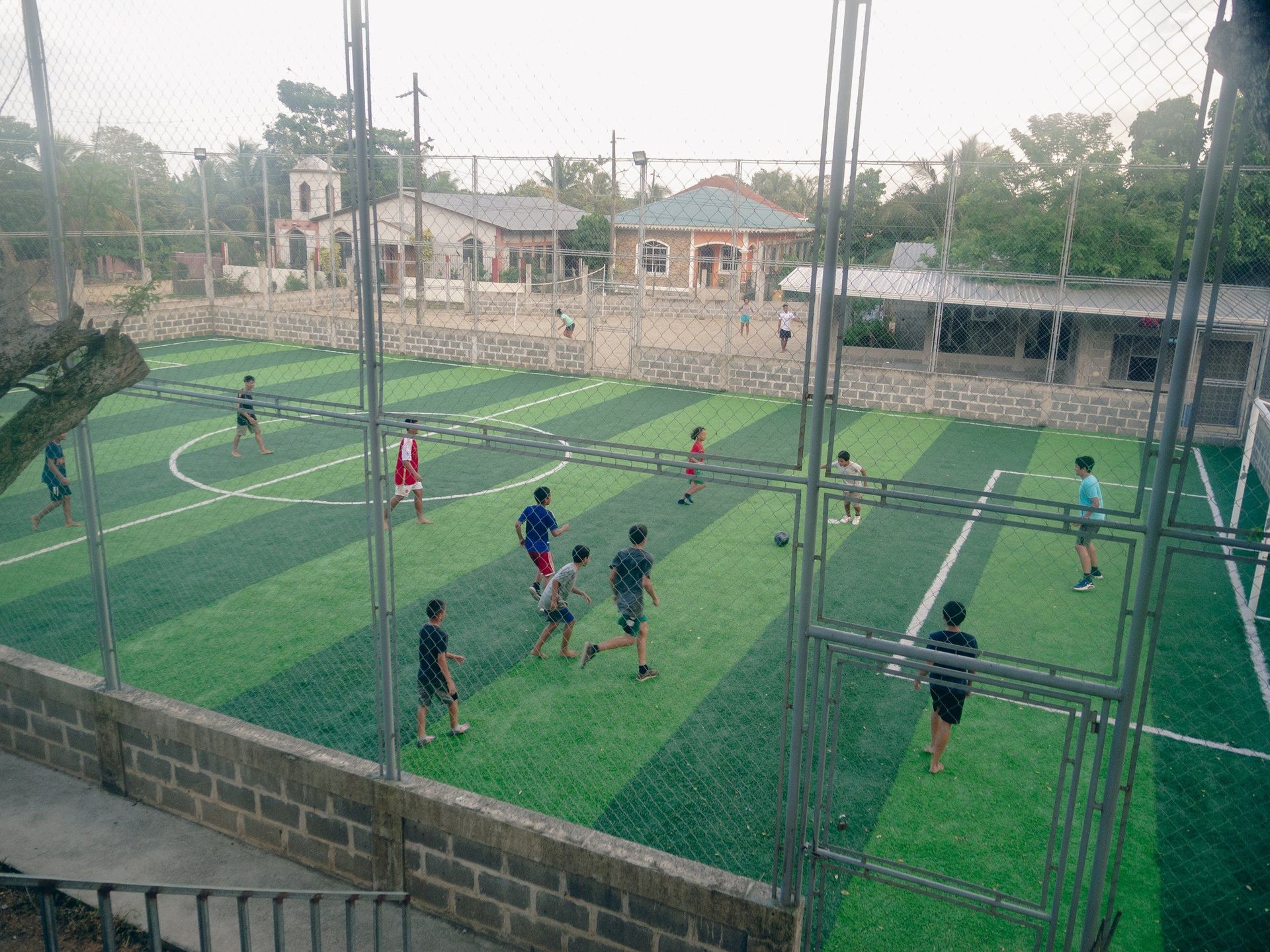 A group of people are playing soccer on a soccer field.