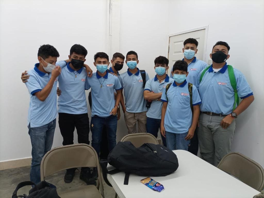 A group of young men wearing face masks are posing for a picture.