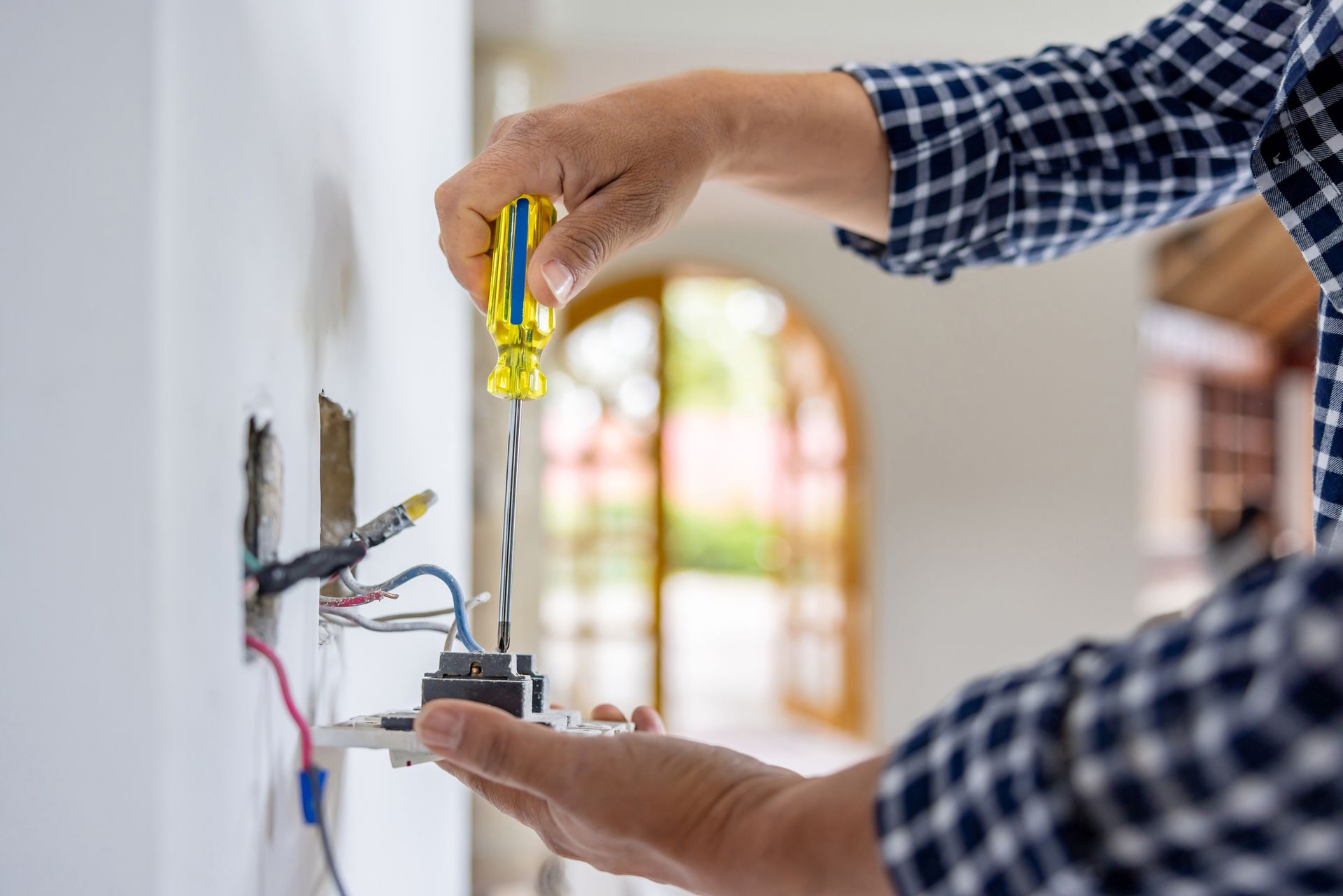 Electrician installing a power outlet.