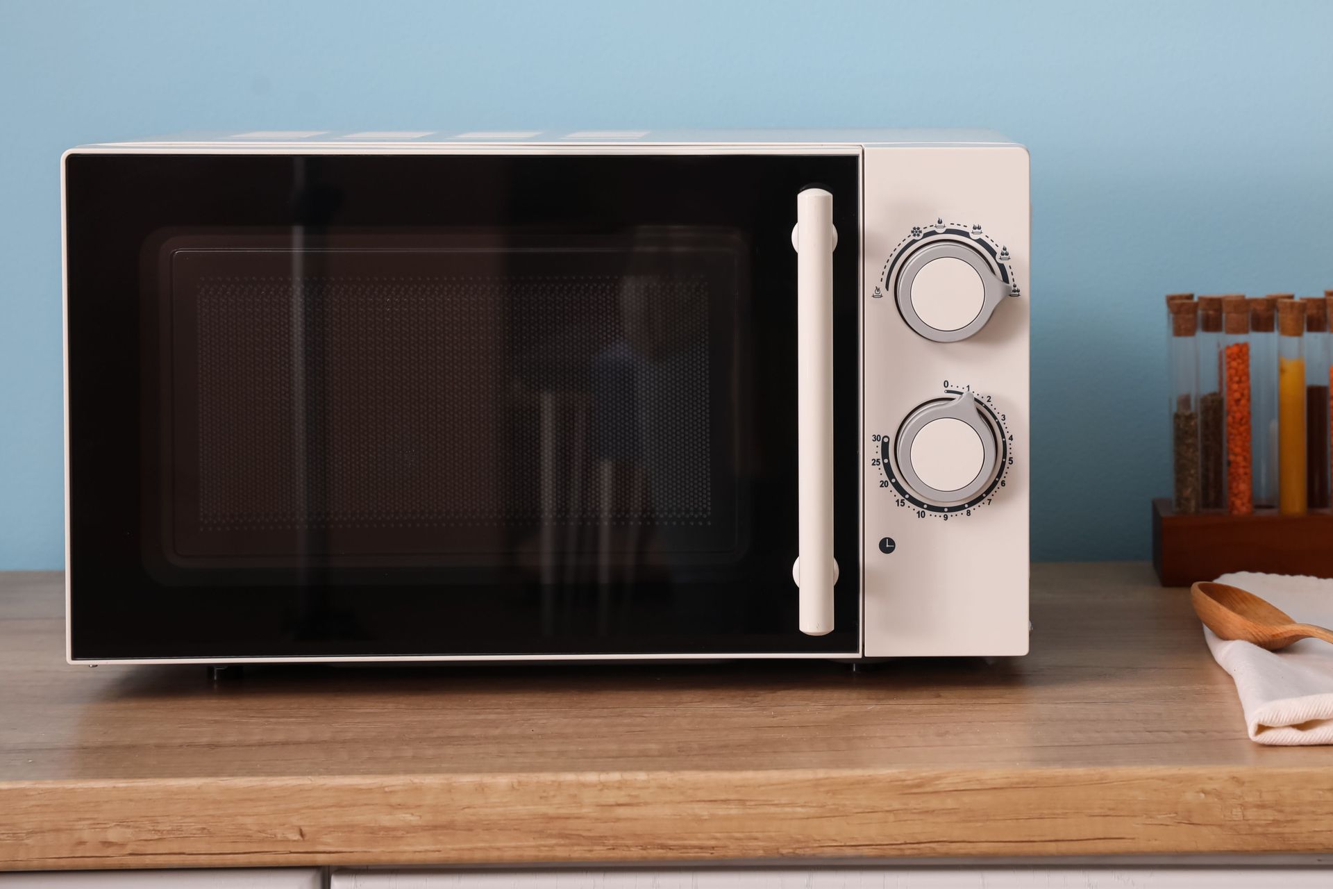 A white microwave oven is sitting on a wooden counter.