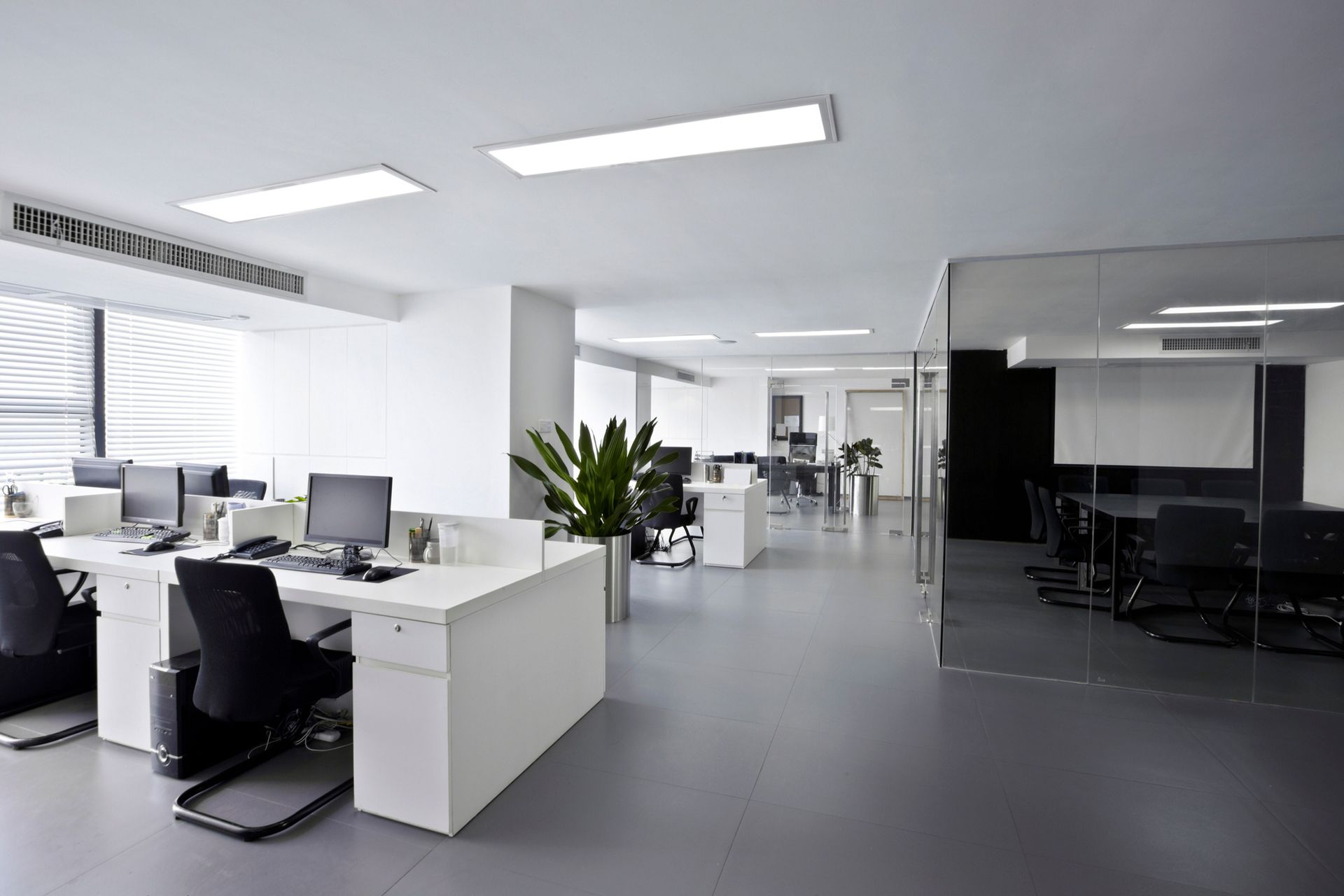 A large empty office with a lot of desks and chairs.