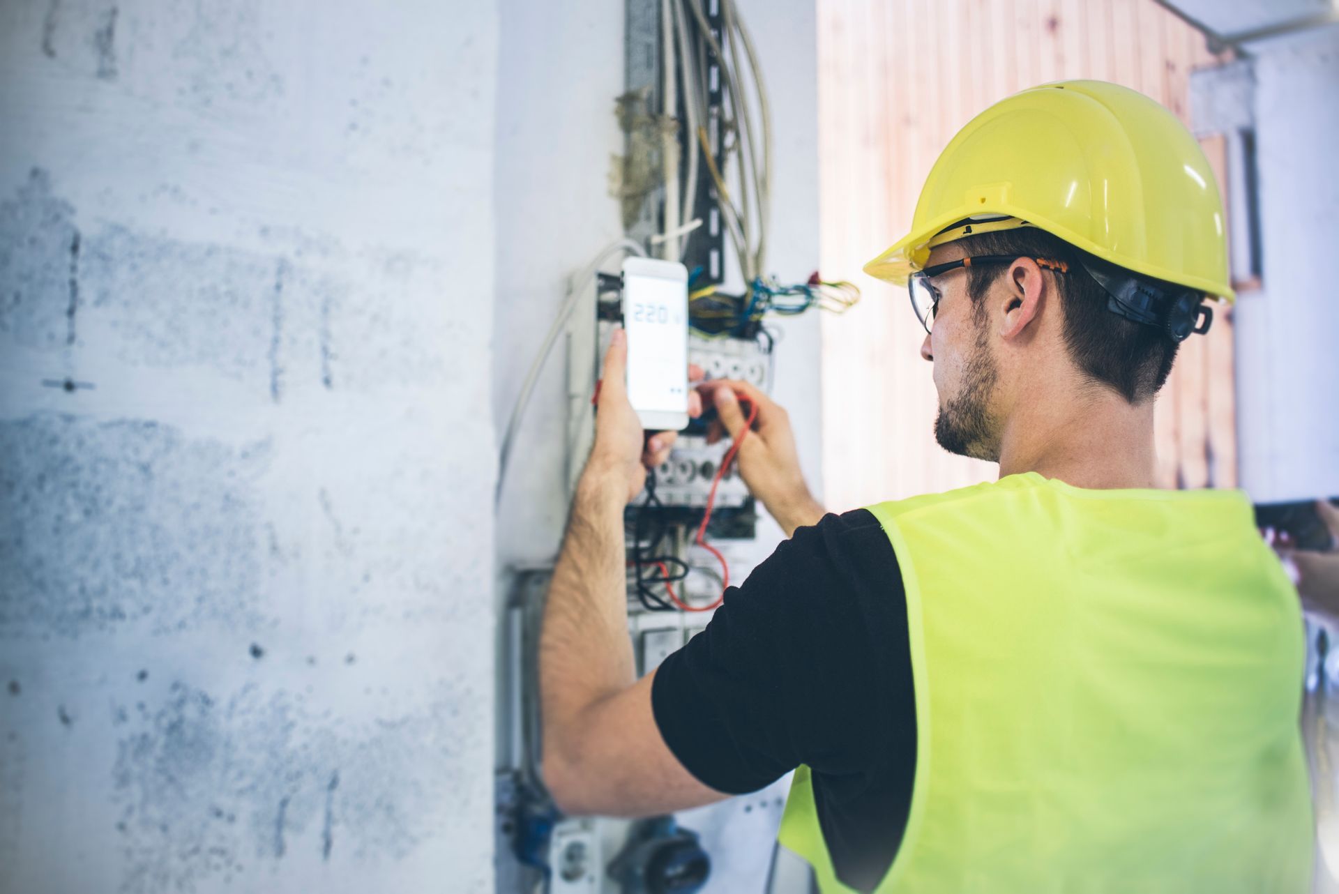 An electrician fixing up the wires and measuring volts