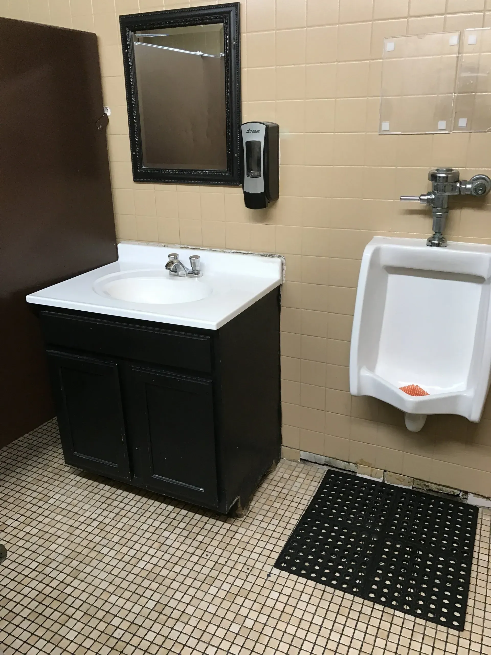 A bathroom with a sink a urinal and a mirror