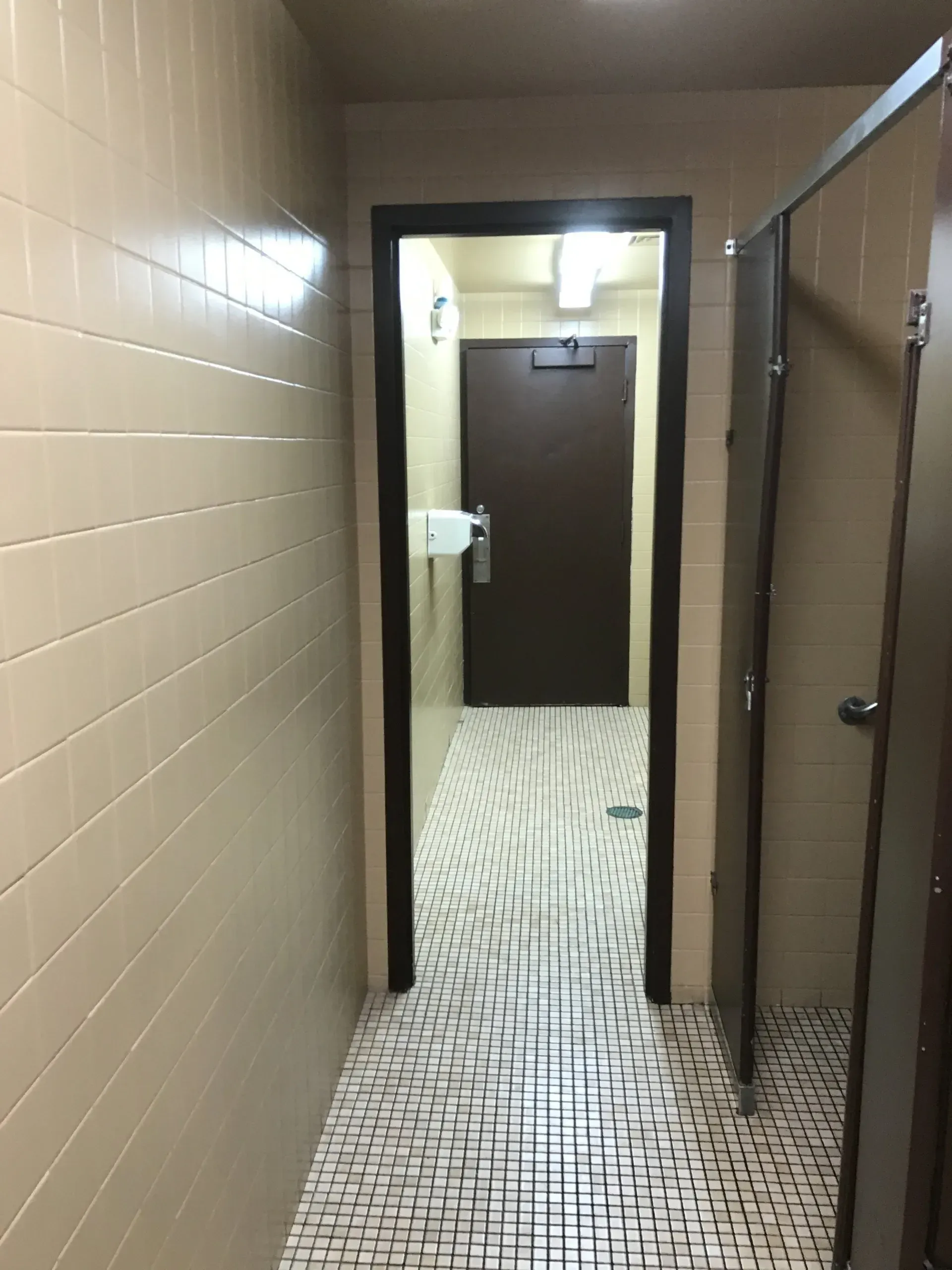 A hallway leading to a door in a bathroom