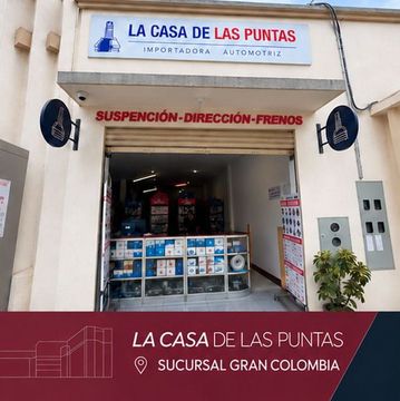 Storefront of “La Casa de las Puntas” auto shop with red “Suspensión-Dirección-Frenos” sign and tire displays