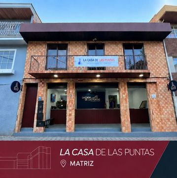 Storefront for “La Casa de las Puntas” in Matriz, with brick facade and large open windows.
