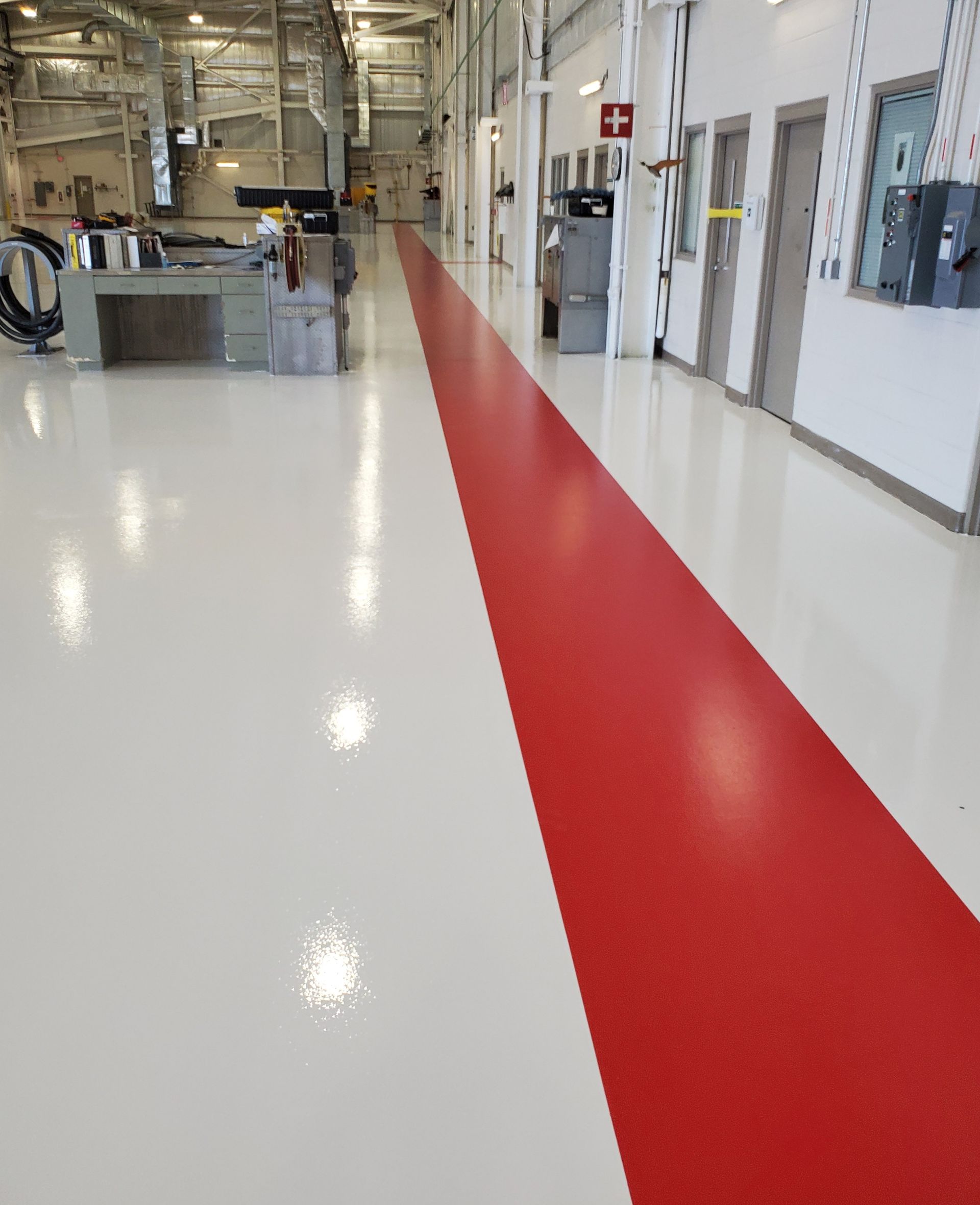 Aviation interior with solid-color epoxy floor including line striping and chemical-resistant urethane topcoat