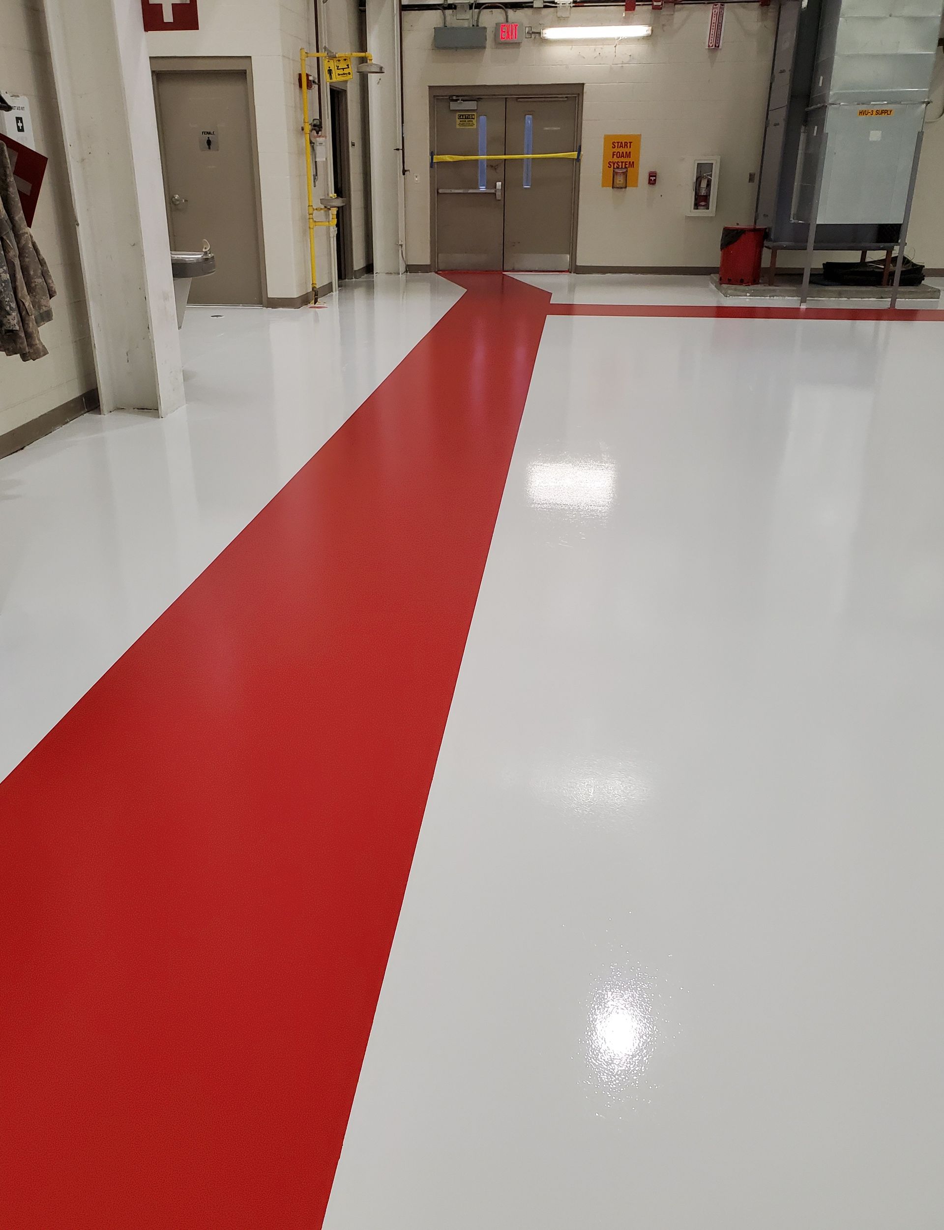 Aviation interior with solid-color epoxy floor including line striping and chemical-resistant urethane topcoat