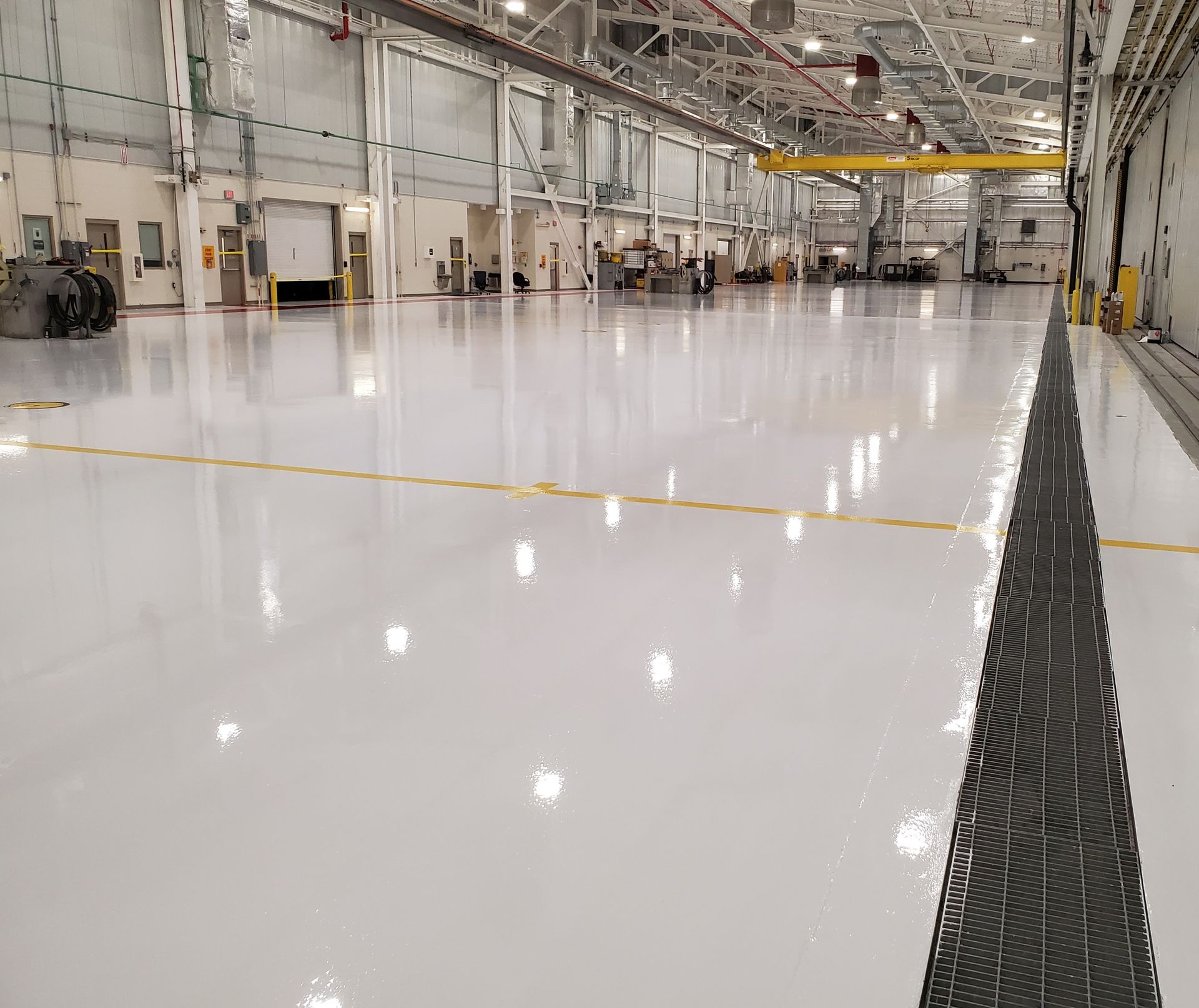 Aviation interior with solid-color epoxy floor including line striping and chemical-resistant urethane topcoat