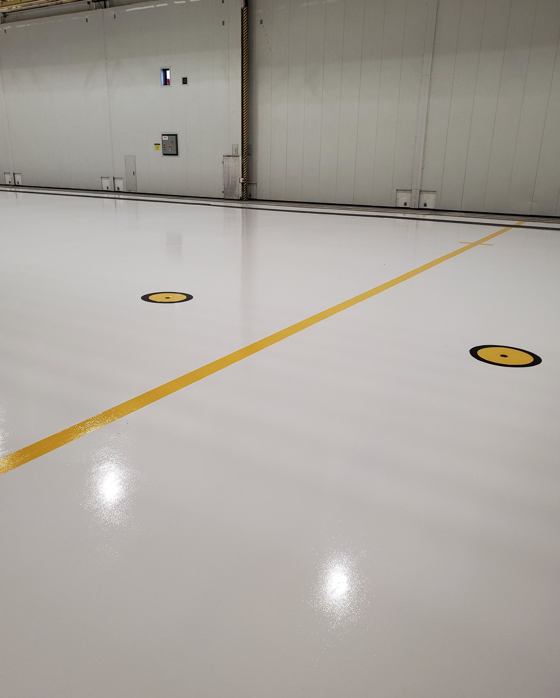 Aviation interior with solid-color epoxy floor including line striping and chemical-resistant urethane topcoat