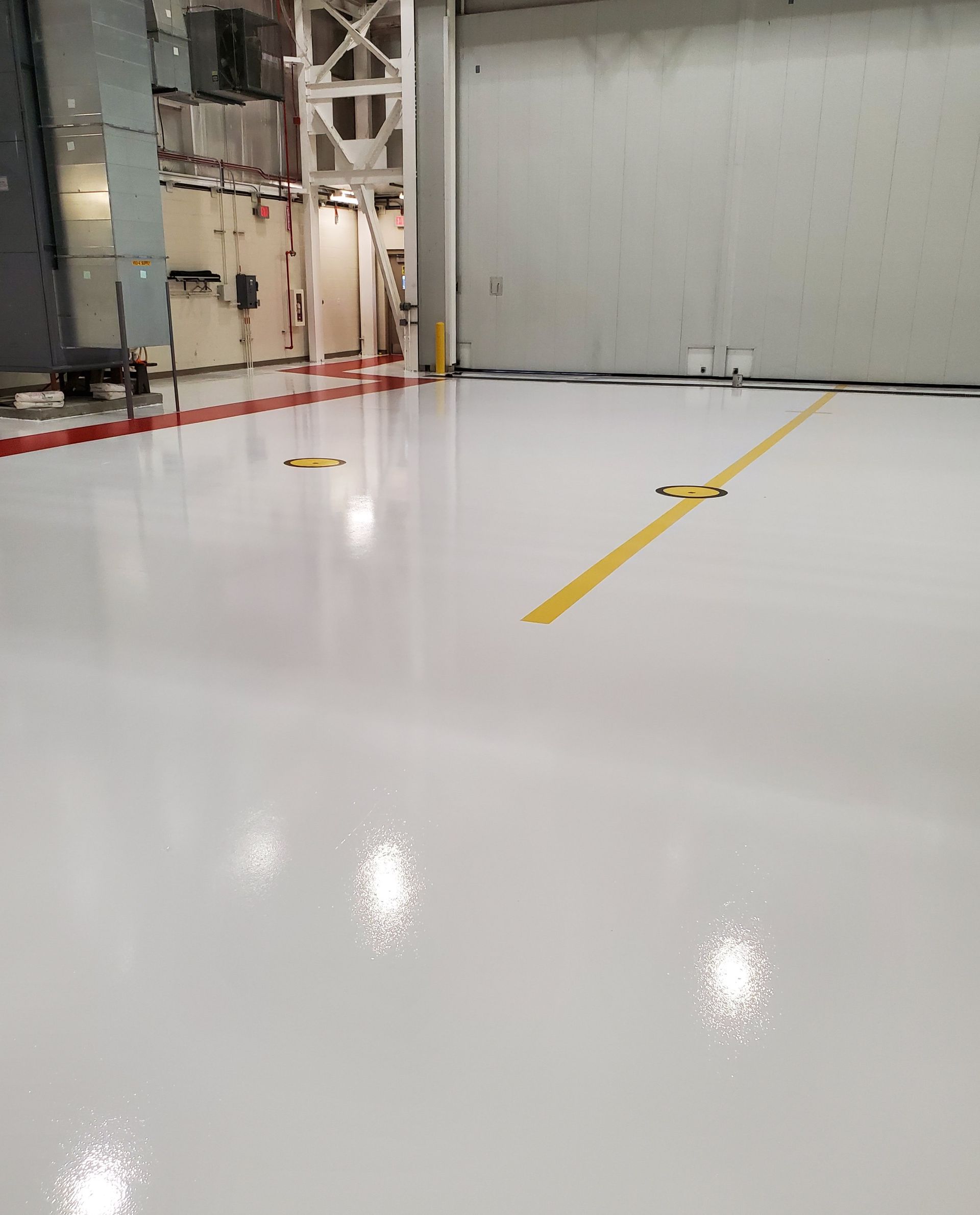 Aviation interior with solid-color epoxy floor including line striping and chemical-resistant urethane topcoat